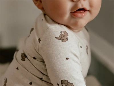 Baby iført That\'s Mine bodystocking i alpaca star med print af bier og bjørne