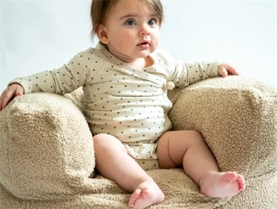 Børnestol i beige fra That\'s Mine med kaninører med barn i stolen