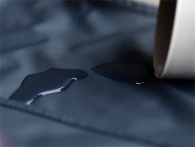 Nærbillede af vandafvisende overflade på Mikk-Line hagesmæk i blue nights