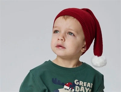 Barn med rød Name It nissehue med hvid kvast