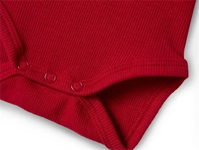 Detalje af rød body fra Name It med trykknapper