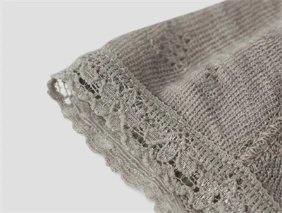 Detalje af Name It babyhue i satellite merinould med blondekant