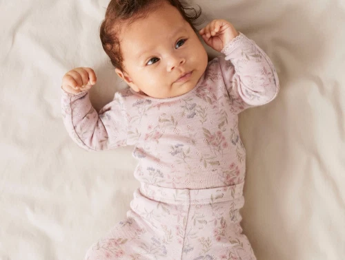Baby iført Name It body i violet ice med blomsterprint