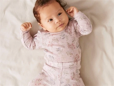 Baby iført Name It body i violet ice med blomsterprint