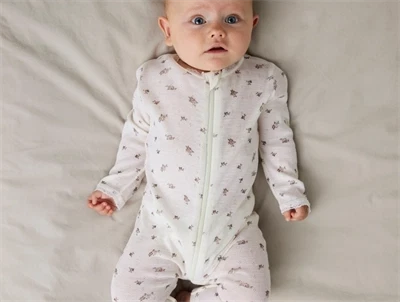 Baby iført Name It uld natdragt i snow white med blomsterprint