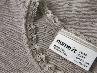 Detalje af Name It uld bluse i satellite med blondekant