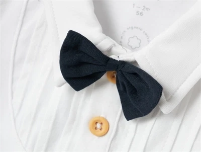 Detalje af sort sløjfe og knapper på hvid body fra Name It