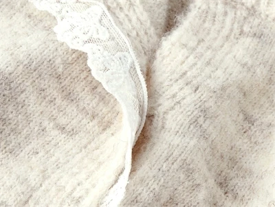 Detalje af blondekant på Name It baby cardigan i peyote melange