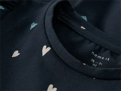 Nærbillede af halsudskæring og hjerteprint på Name It kjole i dark sapphire