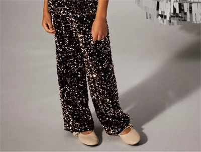 pige iført brune Name It bukser med pailletter