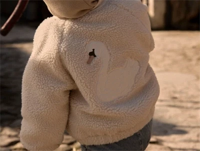 Lil\' Atelier bomberjakke i råhvid teddy set på barn med svanemotiv på ryggen