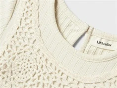 nærbillede af hæklet bryststykke og ribstruktur i lys lil\' atelier kjole