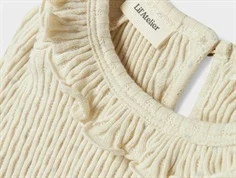 lil\' atelier top i creme med smal rib og flæsedetalje, tæt på halsudskæringen