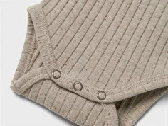 lil\' atelier body i beige med trykknapper og ribstruktur, tæt på benkant