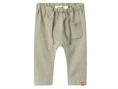 lil' atelier bukser i støvet grøn med frontlomme og bindebånd, set forfra