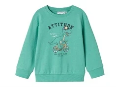 mintgrøn sweatshirt fra name it med print af dinosaur på cykel og teksten attitude, set forfra