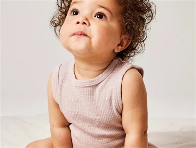 Baby klædt i Name It body i violet ice med ribstruktur