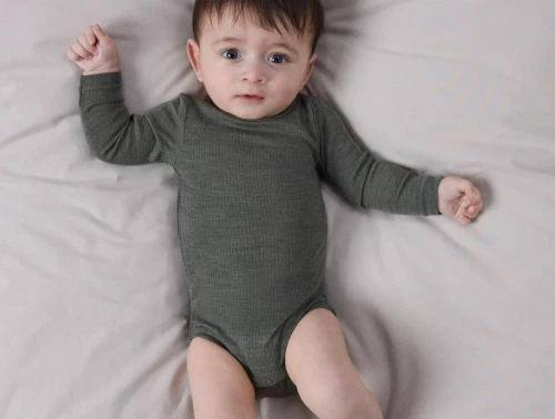 Baby klædt i Name It body i mulled basil i merinould