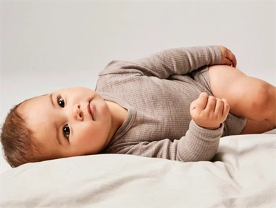Baby klædt i Name It body i satellite i merinould