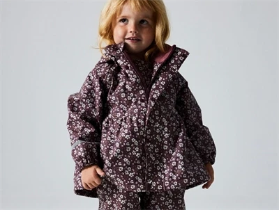 Barn iført Name It regnsæt med blomsterprint i fig farve