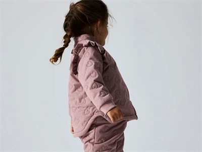 Barn iført rosa Name It termosæt med hjertequilt og flæser