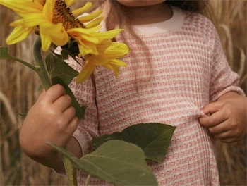 Strikbluse i misty rose fra Lil\' Atelier med ribkant Barn i Lil\' Atelier strikbluse i misty rose holder solsikke