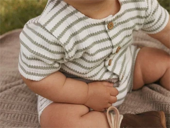 Baby iført Lil\' Atelier jumpsuit med grønne striber