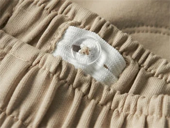 Nærbillede af elastik og knapjustering i taljen på Lil\' Atelier shorts i irish cream