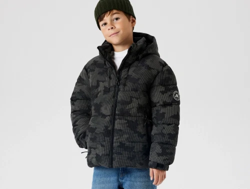 Dreng iklædt Name It pufferjakke black til børn med aftagelig hætte