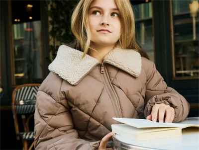 Pige iklædt Name It pufferjakke i beige nuance med teddykrave