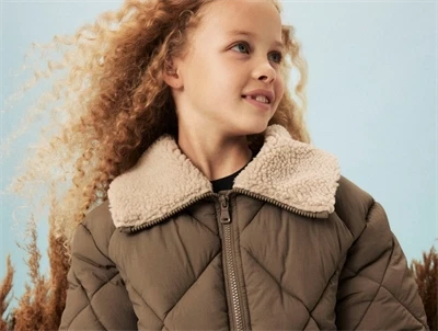 Pige iført brun Name It pufferjakke med teddykrave