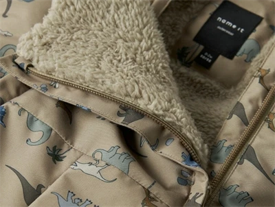 Foerdetalje på Name It flyverdragt silver mink med dinosaurprint