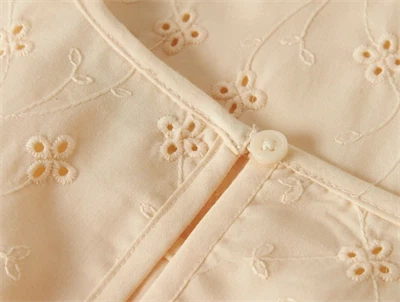 detalje af knaplukning bagpå broderet top fra Name It i buttercream