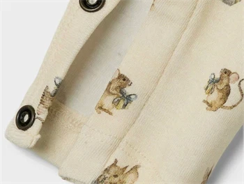 Detalje af museprint og trykknapper på Lil\' Atelier heldragt i turtledove