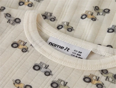 Name it body i merinould råhvid med traktorer closeup ved hals