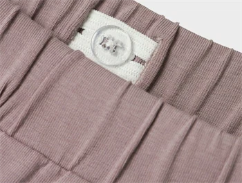 Nærbillede af justerbar elastik i taljen på lilla shorts