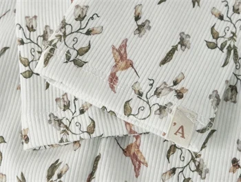 Nærbillede af print og sømme på Lil\' Atelier leggings med kolibrier