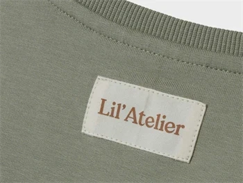 Nærbillede af Lil\' Atelier logo på sweatshirt i seagrass