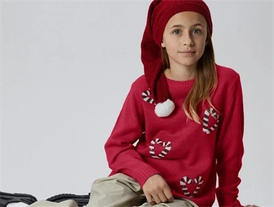 Pige iført Name It juletrøje i rød med paliet hjerter