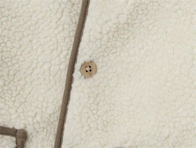 Nærbillede af knap på Lil\' Atelier teddyvest i turtledove