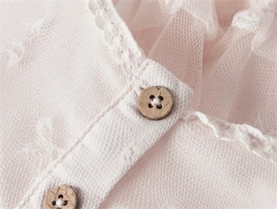 Detalje af knaplukning på Lil\' Atelier babykjole i almost mauve