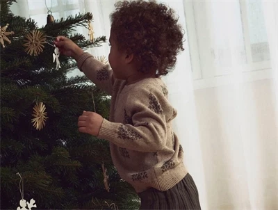 Barn iført Lil\' Atelier striktrøje i oxford tan med juletræer