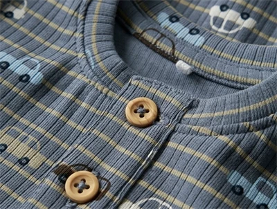 Detalje af knapper på blå body med biler fra Name It