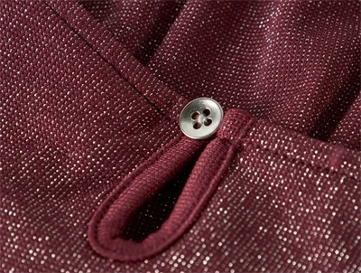 Detalje af knaplukning og glimmer på burgundy Name It kjole