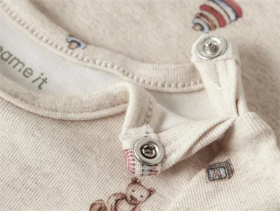 Detalje af trykknapper på råhvid rib body fra Name It