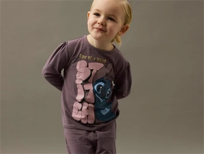 Barn iført lilla Stitch natdragt fra Name It