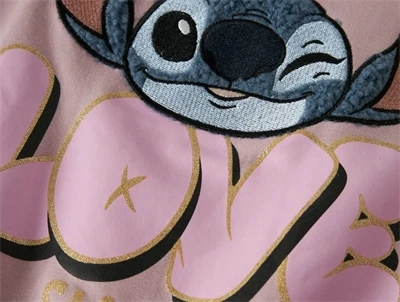 Close-up af Stitch og LOVE glimmerprint på sweatshirt soft pink