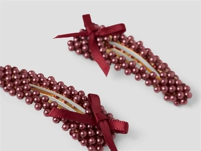 Detaljebillede af hårspænder i bordeaux fra Name It med perler og sløjfe
