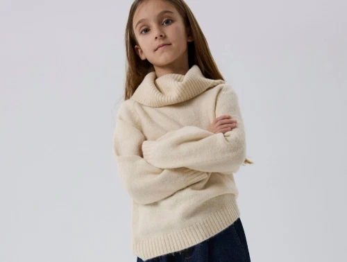 Pige iført Name It striktrøje beige med høj krave