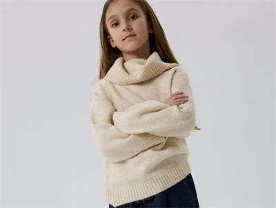 Pige iført Name It striktrøje beige med høj krave